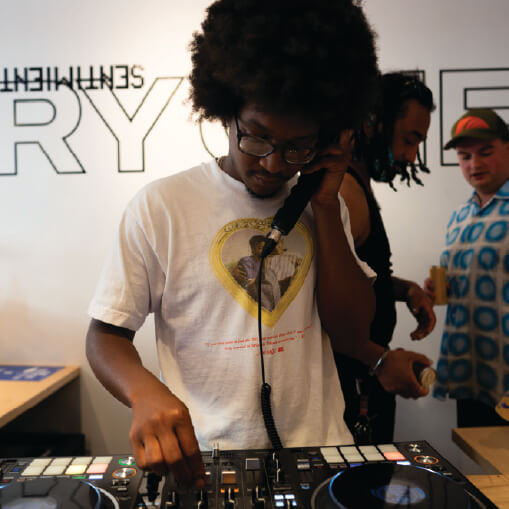 DJ adjusting faders and holding mic