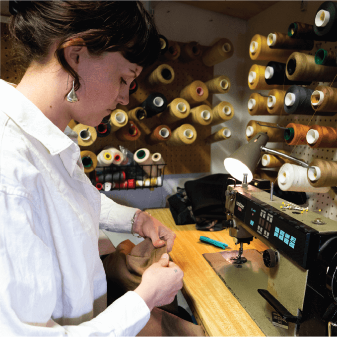 Person sews pants at sewing machine